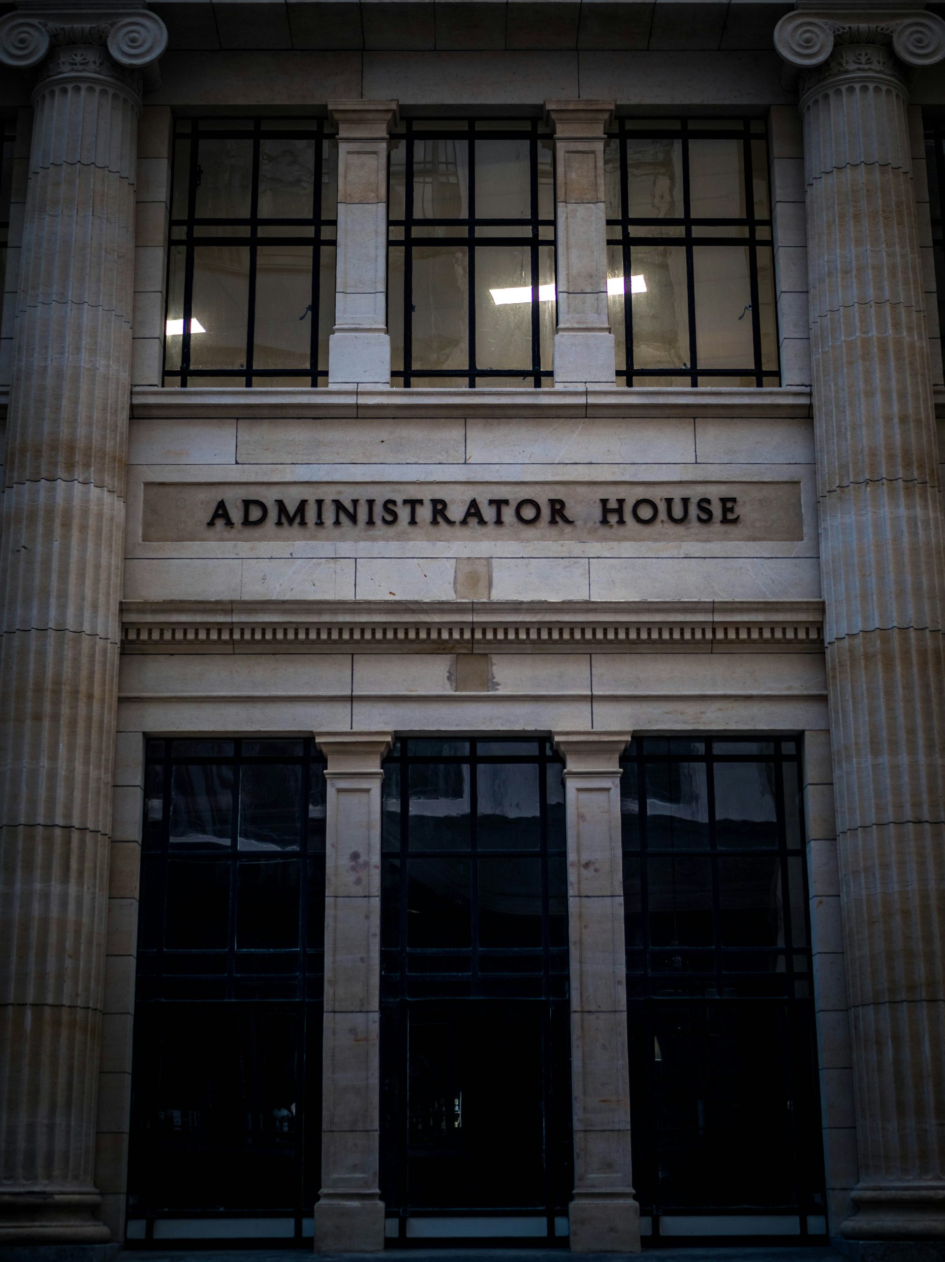 the front of a building with columns and a clock